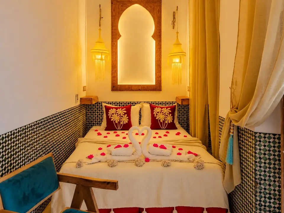 Zellige room with a carved arch mirror and green tiles