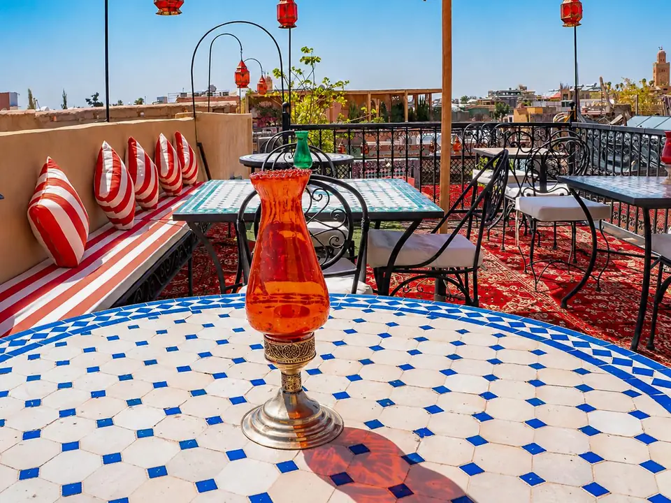 A zellige table with an amber glass lantern on the rooftop