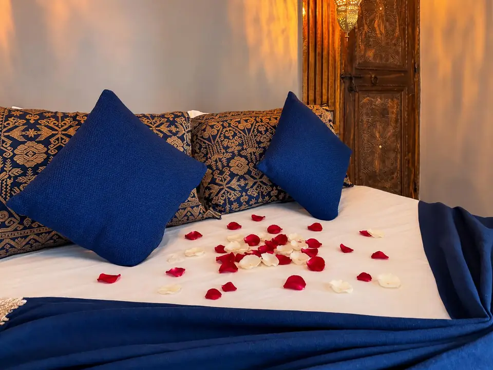 Atlas suite bed with indigo cushions and rose petals